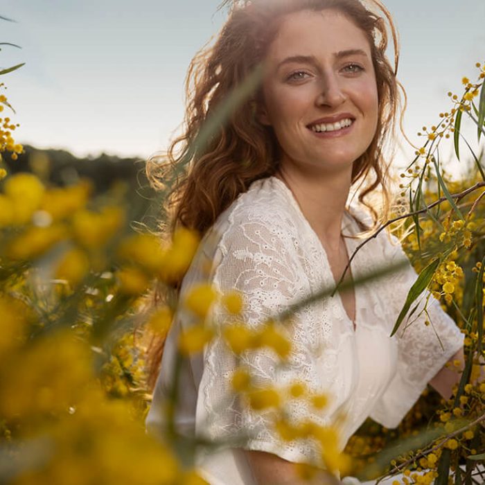 mujer-sonriente-tiro-medio-posando-flor-estepa